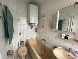a bathroom with a tub and a sink and a toilet at Cozy Apartment in Spandau Rauchstr with Garden View in Berlin +48 photos