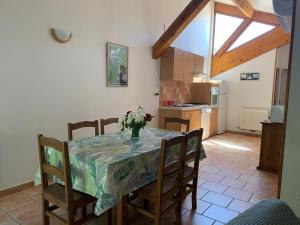 a kitchen with a table with a vase of flowers on it at Les Gîtes La Chareyre in Thueyts