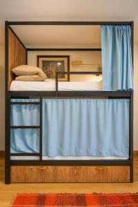 a bunk bed with a blue curtain in a room at Hostel El Cascabel in Granada