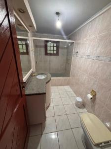 a bathroom with a toilet and a sink and a tub at Beach House Dunas da Joaquina in Florianópolis