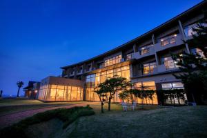 a large building with a lot of windows at night at Ocean Resort Nomon長崎 in Nomo