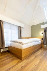 a large bed in a room with a large window at Hotel R5 Budget - Chur in Chur