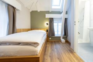 a bedroom with a bed and a bathroom at Hotel R5 Budget - Chur in Chur