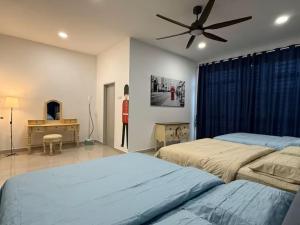 a bedroom with two beds and a ceiling fan at TropINN LoDonHeartBeat 5LuxRoom CirPool BBQ & KTVFun in Bandar Penawar