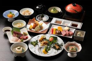 a table with plates of food and bowls of food at Ocean Resort Nomon長崎 in Nomo