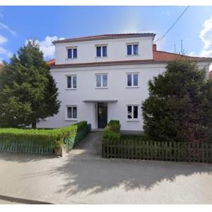 a white house with a fence in front of it at Studio 9 Żeromskiego in Gorzów Wielkopolski