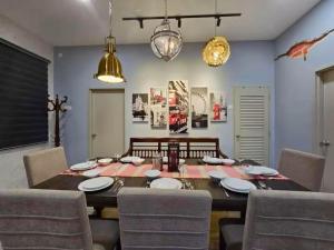 a dining room with a wooden table and chairs at TropINN LoDonHeartBeat 5LuxRoom CirPool BBQ & KTVFun in Bandar Penawar