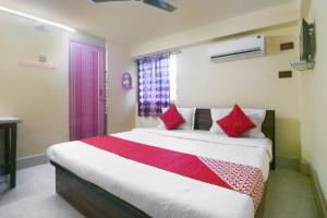 KharagpurHotel O Shyam Guest House的卧室里有一张大床，配有红色枕头