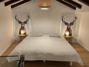 a bedroom with a bed with two deer heads on the wall at Il Nido by Fewotessin in Ronco s/Ascona - Porto Ronco