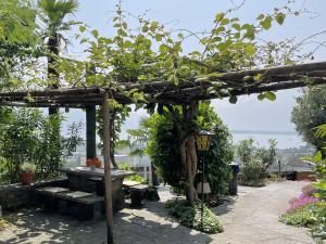 une pergola en bois avec un banc et une table dans l'établissement Casa Colombina & Studio by Fewotessin, à Gordola