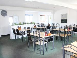 a dining room with tables and chairs and a clock at Byards Leap Lodges in Welbourn
