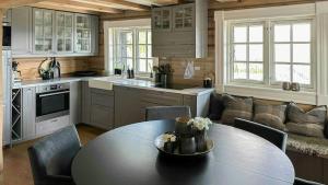 eine Küche mit Tisch und Stühlen und einer Couch in der Unterkunft Log Cabin With Panoramic Views At Voss Resort in Skulestadmo