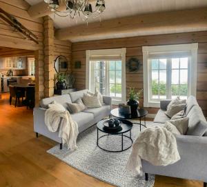 a living room with a couch and a table at Log Cabin With Panoramic Views At Voss Resort in Skulestadmo