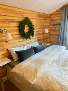 ein Schlafzimmer mit einem Bett mit einem Kranz an der Wand in der Unterkunft Log Cabin With Panoramic Views At Voss Resort in Skulestadmo