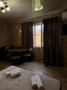 Un dormitorio con una cama y una mesa y una ventana. en Panorama Gora, en Kutaisi