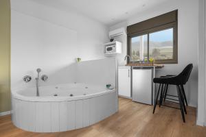 a large white bath tub in a kitchen with a chair at Mikiway סוויטה פנורמית בגלבוע in Bet HaShitta +32 photos