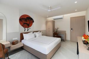 ein Schlafzimmer mit einem großen weißen Bett und einem Schreibtisch in der Unterkunft Champion Prime-My Downtown Hotel in Udaipur + 17 Fotos