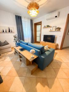 a living room with a blue couch and a table at Casa Montebello in Camaiore