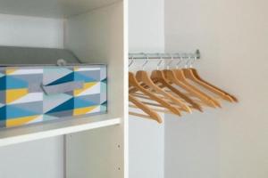 a closet with a tv and some wooden hangers at Le Studio Cocooning in Chartres