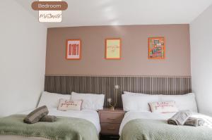two beds in a bedroom with green and white at 3BR House By MyStayUK Short Lets & Serviced Accommodation Manchester With Free Wifi & Free Parking in Manchester