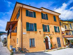 a orange building with green shutters on a street at Casa Montebello in Camaiore