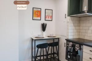 a kitchen with a small table and two stools at 3BR House By MyStayUK Short Lets & Serviced Accommodation Manchester With Free Wifi & Free Parking in Manchester