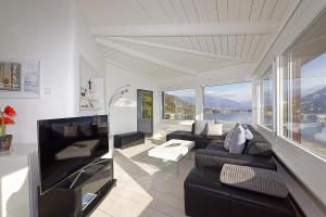 a living room with a couch and a large window at Casa Rondine by Fewotessin in Ronco s/Ascona - Porto Ronco