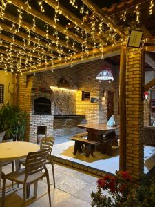 a patio with a table and a brick wall with lights at Chalés 4 Estações in Beberibe