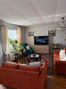 ハンコにあるJoyce holiday placeのリビングルーム(オレンジ色のソファ、テレビ付)