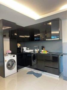 eine Küche mit Waschmaschine und Waschmaschine in der Unterkunft Club Royal C324 in Pattaya North