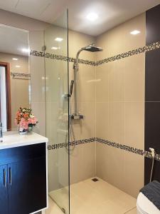 eine Glasdusche im Bad mit Waschbecken in der Unterkunft Club Royal C324 in Pattaya North