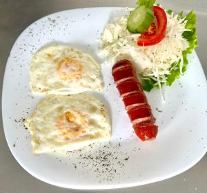 a plate of food with a sausage and salad at Prenoćište Vozač in Jajce