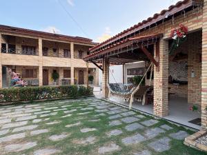 a brick building with a patio with a yard at Chalés 4 Estações in Beberibe