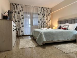 Un dormitorio con una cama y una ventana con cortinas. en Geany Apartament Ultracentral, en Craiova