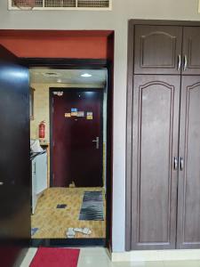 un corridoio che conduce a una cucina con porta di استديو لشخصين ad Ajman