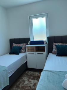 Un dormitorio con dos camas con espejo y ventana. en Vila Ayla, en Blagaj