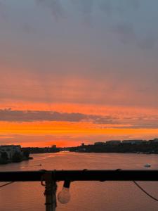 a sunset over a body of water at Central waterfront luxury penthouse in Stockholm