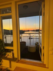 a window of a balcony with a view of the water at Central waterfront luxury penthouse in Stockholm
