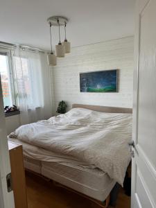 a bed in a bedroom with a white wall at Central waterfront luxury penthouse in Stockholm