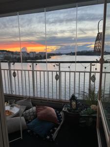 a balcony with a view of the water at sunset at Central waterfront luxury penthouse in Stockholm