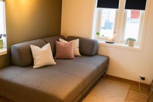 een bank met vier kussens in een kamer bij Cottage studio in city centre in Tromsø