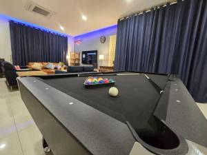 a pool table in a living room with a billiard at TropINN LoDonHeartBeat 5LuxRoom CirPool BBQ & KTVFun in Bandar Penawar