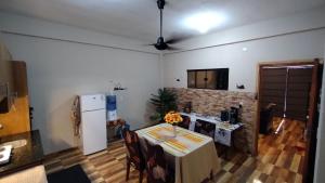 Una cocina con una mesa y un refrigerador blanco. en Ort des Entstehens, 