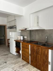 a kitchen with wooden cabinets and a sink and refrigerator at Greco Mare 99 in Kavos