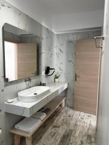 a bathroom with a sink and a mirror at Greco Mare 99 in Kavos +21 photos