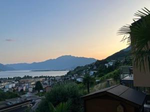a view of a city with the ocean and mountains at Casa Colombina Duplex by Fewotessin in Gordola