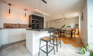 a kitchen and dining room with a bar with stools at La Cave des Miracles in Dracy-le-Fort