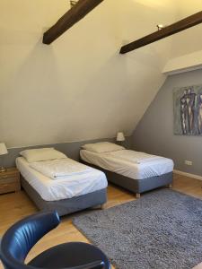 two beds in a room with a chair and a rug at Ferienhaus Strandoase in Oldenburg in Holstein