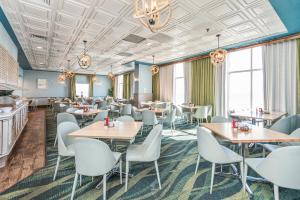 uma sala de jantar com mesas, cadeiras e janelas em A Caribbean Oasis at SeaWatch em Myrtle Beach