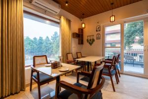 a dining room with a table and chairs and a large window at Sandane Homes in Greater Noida